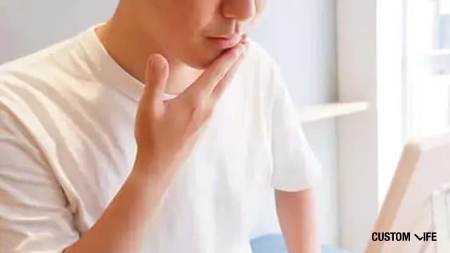 鏡の前でヒゲを見つめる男性