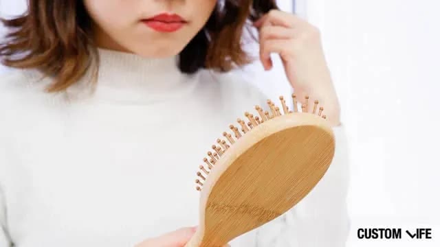 ブラシについた抜け毛を気にする女性