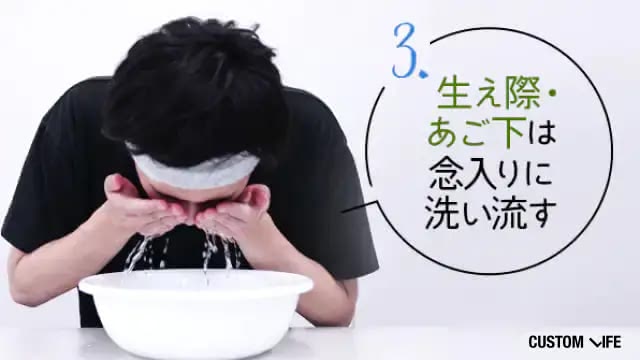 洗顔料を洗い流している男性