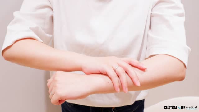 腕を触る女性
