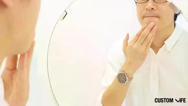 鏡の前でヒゲを気にしている男性の写真