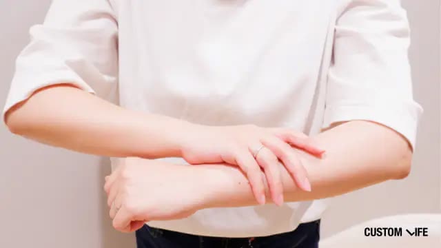 腕を触る女性