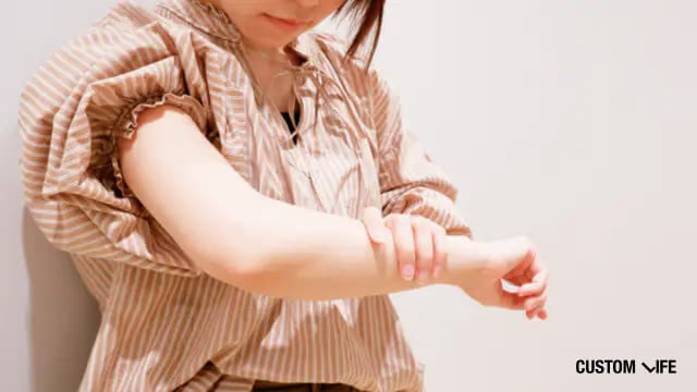 腕を見る女性